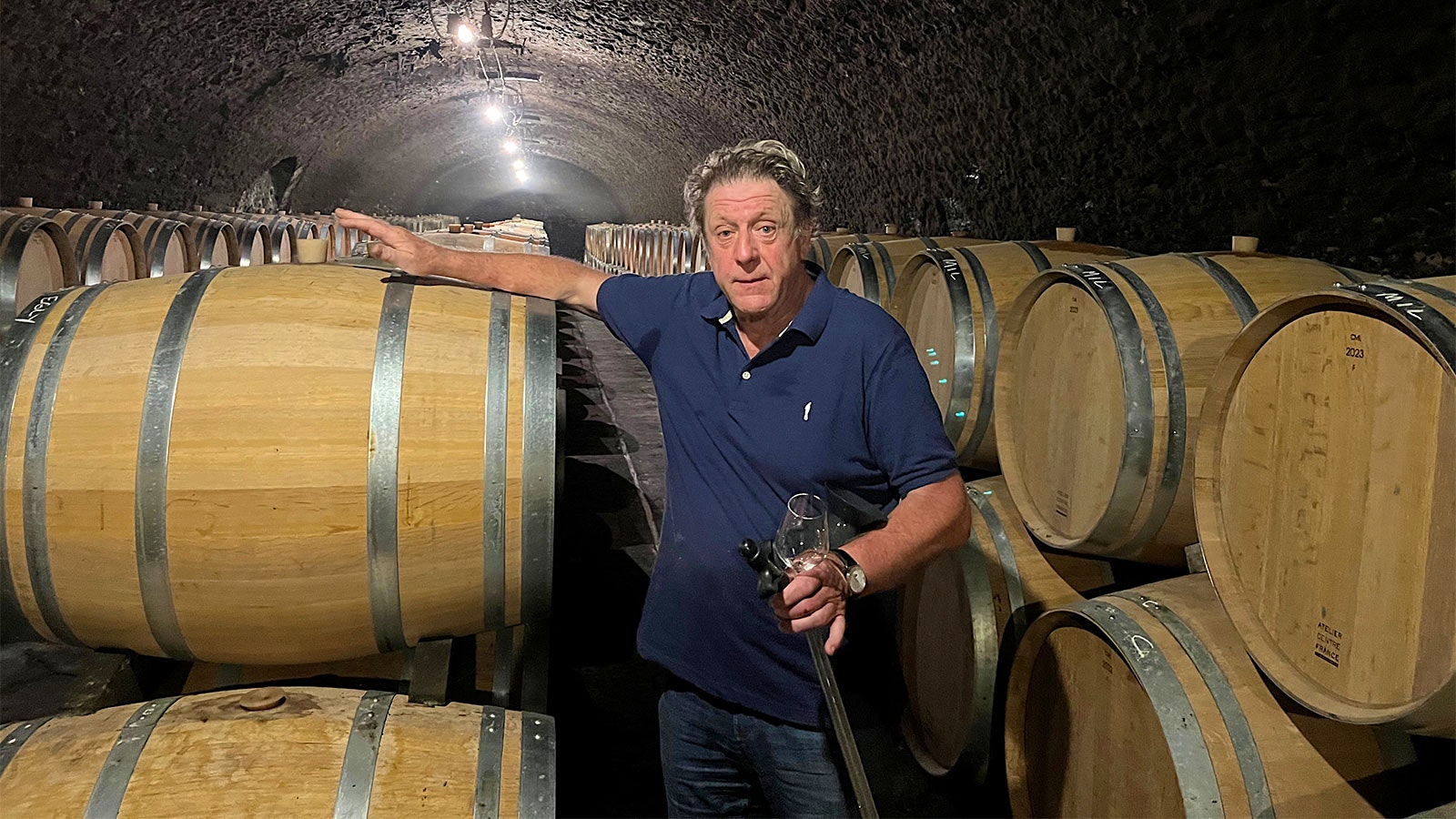 Champagne producer Anselme Selosse stands amid wine barrels in his cellar